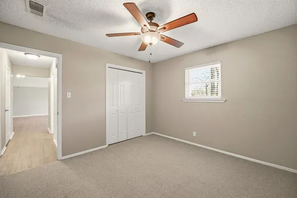 an empty room with fan and windows