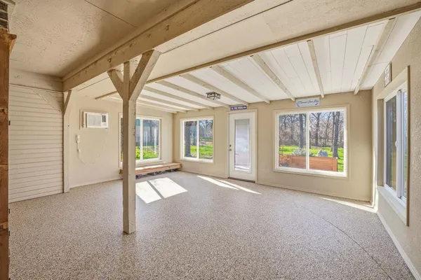 a view of an empty room with a fireplace and a window