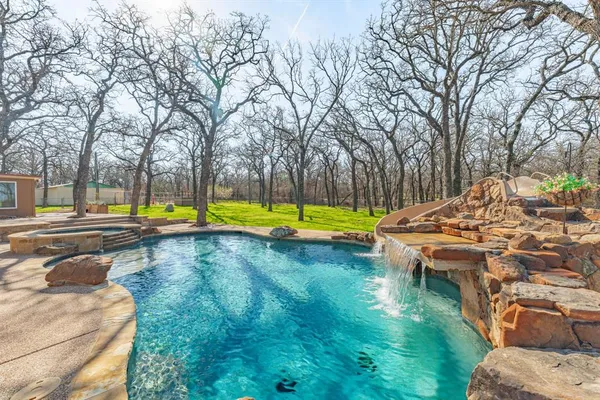 a view of a swimming pool with lounge chairs in patio