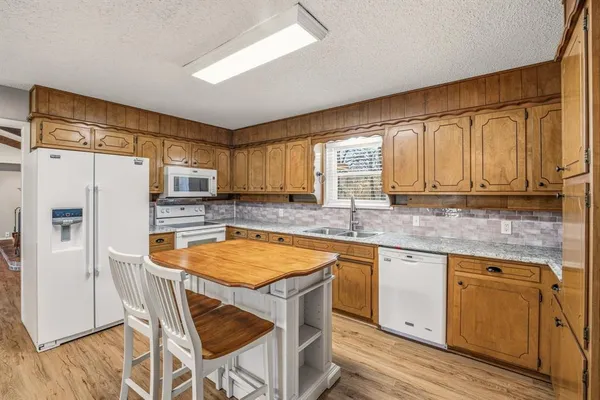 a kitchen with stainless steel appliances granite countertop a stove refrigerator sink and cabinets
