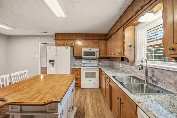 a kitchen with stainless steel appliances granite countertop a sink a stove and a refrigerator