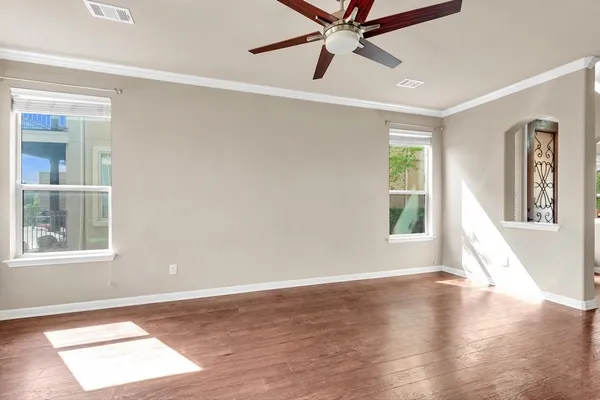 a view of a big room with wooden floor and windows