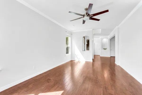 a view of a livingroom with wooden floor and a ceiling fan