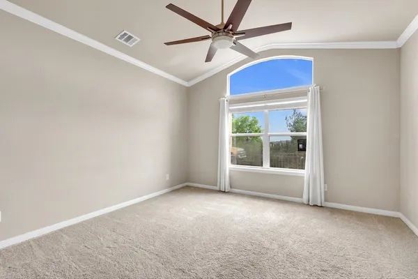an empty room with windows and fan