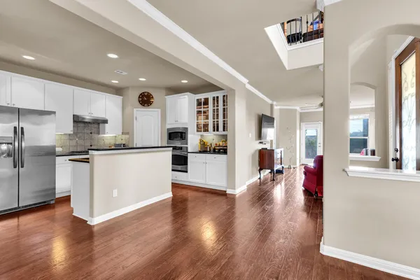 a large white kitchen with lots of counter top space and stainless steel appliances