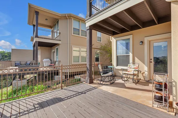 a view of a patio with table and chairs with wooden floor and fence
