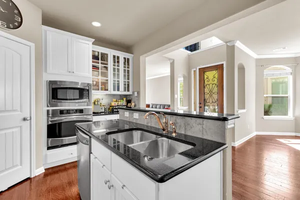 a kitchen with granite countertop a sink and a stove top oven