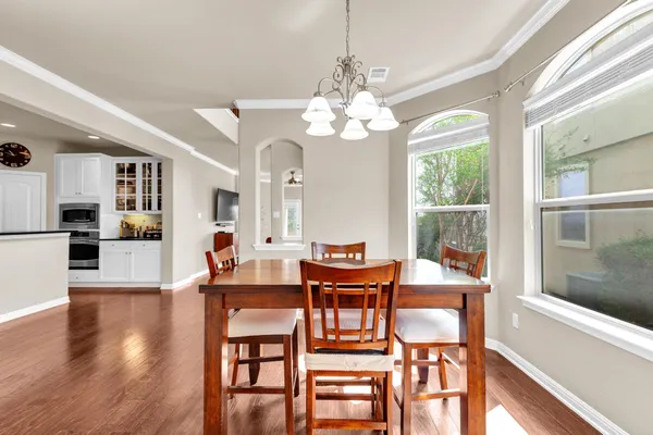 a view of a dining room with furniture a chandelier and wooden floor