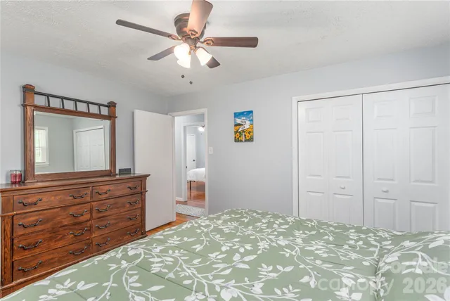 a bedroom with a large bed and a large mirror on dresser