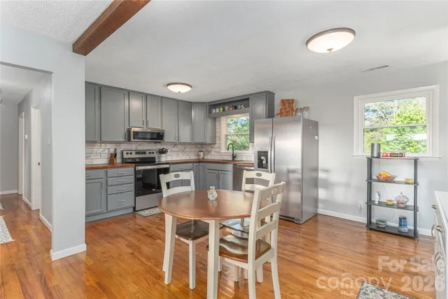 a kitchen with granite countertop a refrigerator and a stove top oven