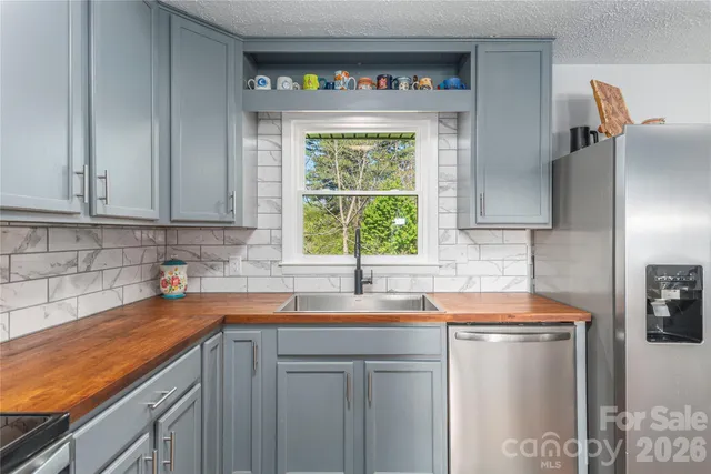 a kitchen with stainless steel appliances a sink stove and window