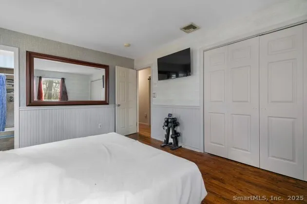 a bedroom with a bed and a flat screen tv