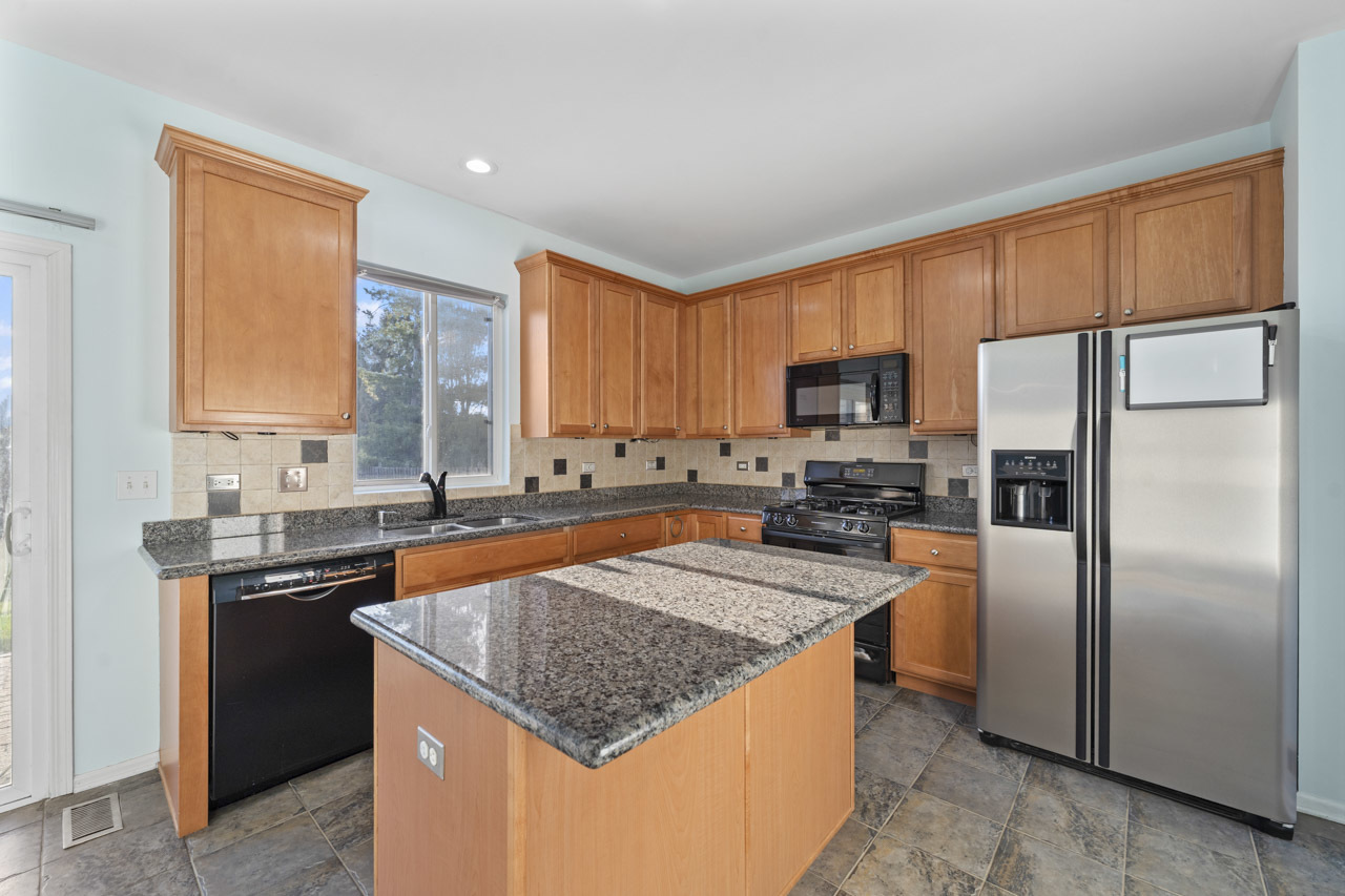 149 Lilac Street Bolingbrook, IL 60490 - Photo 13 of 50 a kitchen with stainless steel appliances granite countertop a stove top oven a refrigerator a sink and dishwasher with wooden floor