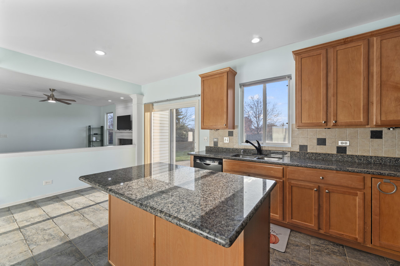 149 Lilac Street Bolingbrook, IL 60490 - Photo 14 of 50 a kitchen with stainless steel appliances granite countertop a sink stove and cabinets