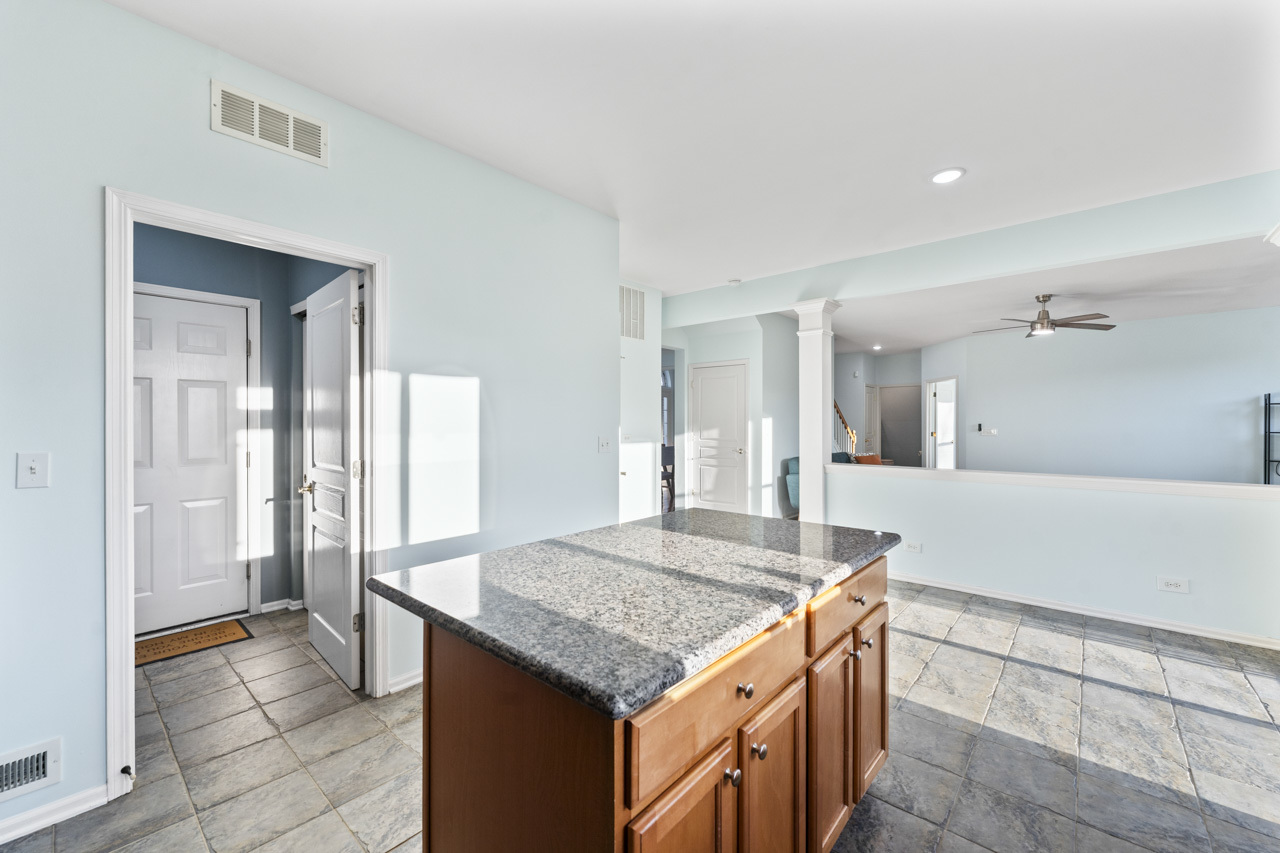149 Lilac Street Bolingbrook, IL 60490 - Photo 15 of 50 a kitchen with kitchen island a sink a counter top and living room view