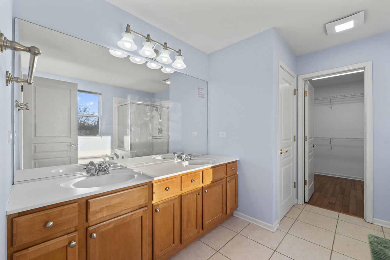 149 Lilac Street Bolingbrook, IL 60490 - Photo 24 of 50 a spacious bathroom with a granite countertop sink a mirror and a shower
