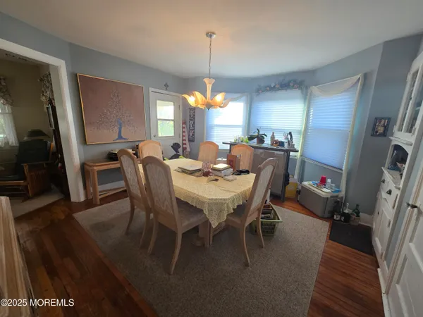 a dining room with furniture window and wooden floor