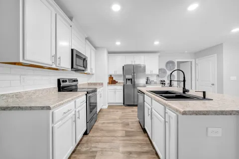 a kitchen with stainless steel appliances granite countertop a sink and cabinets