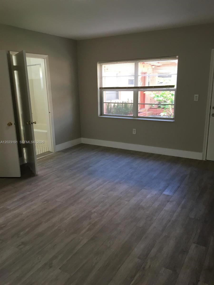 520 Southwest 4th Street, Unit 5 Miami, FL 33130 - Photo 10 of 11 an empty room with wooden floor and windows