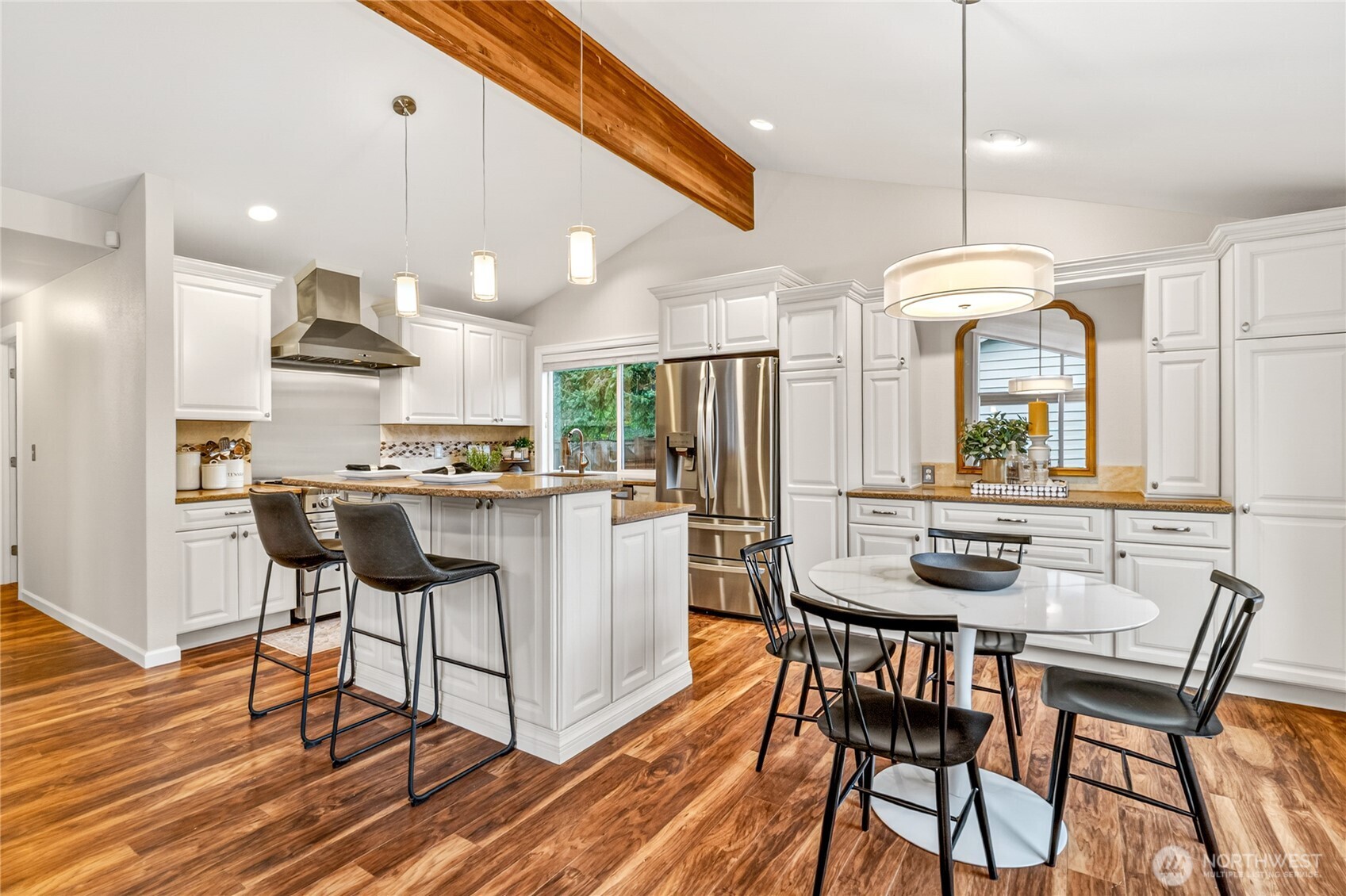 13236 Southeast 161st Place Renton, WA 98058 - Photo 12 of 38 a kitchen with stainless steel appliances kitchen island granite countertop a dining table chairs and white cabinets