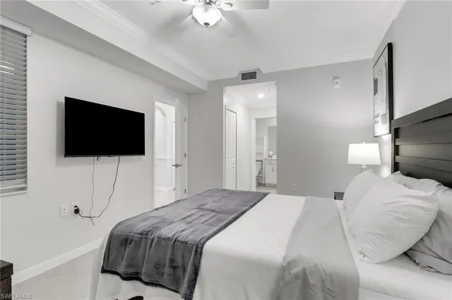 a bedroom with a bed tv and a chandelier