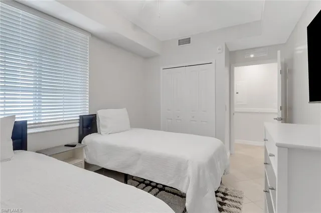 a bedroom with two beds and a large mirror