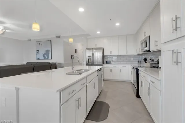 a kitchen with stainless steel appliances kitchen island a sink stove and cabinets