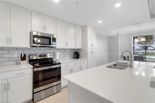 a kitchen with sink a microwave and cabinets