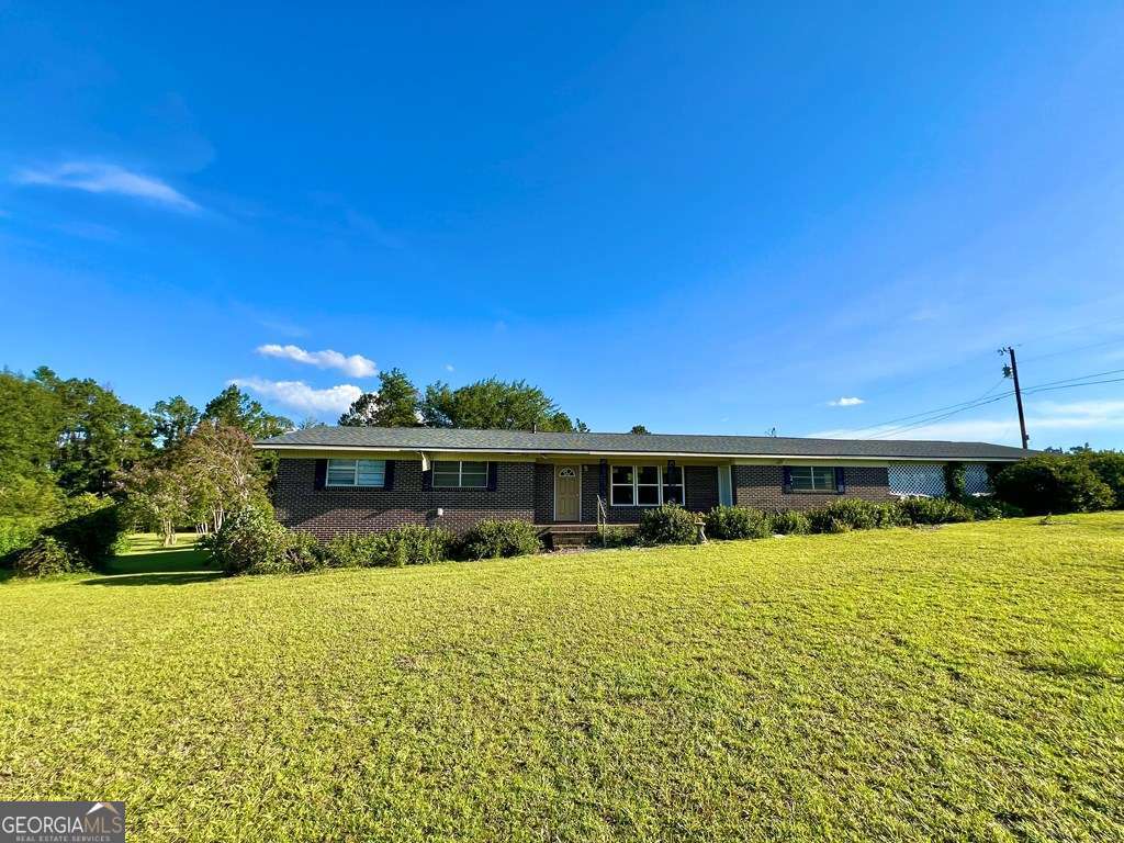 a view of swimming pool with outdoor seating and house in the background