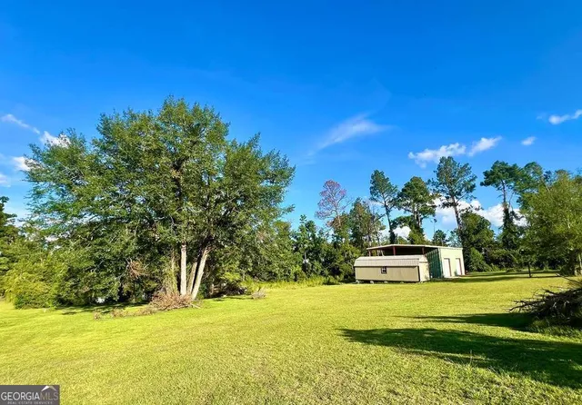 a view of a livingroom with wooden floor and a bathroom