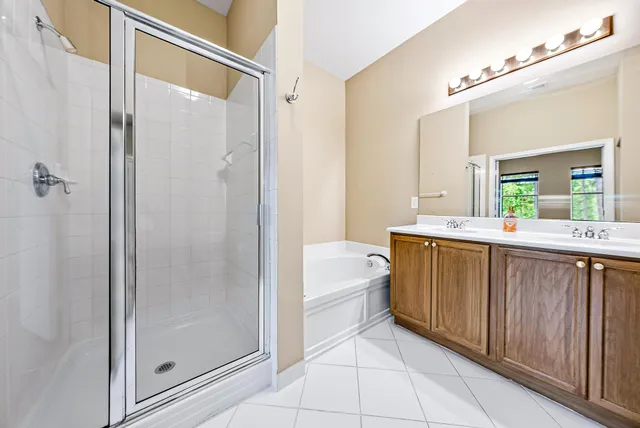 a bathroom with a tub sink and mirror