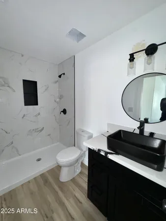a bathroom with a sink toilet a mirror and shower