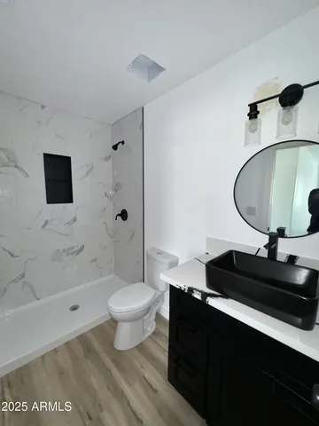 a bathroom with a sink toilet a mirror and shower