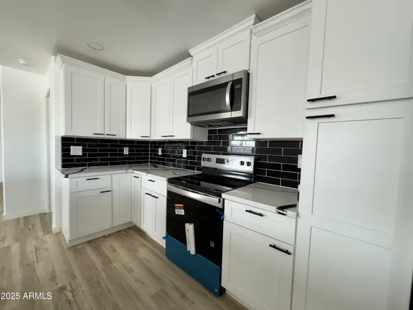 a kitchen with stainless steel appliances granite countertop a stove and a microwave