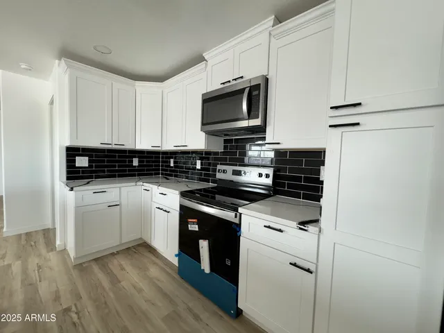 a kitchen with stainless steel appliances granite countertop a stove and a microwave