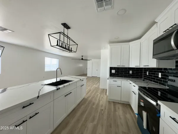 a kitchen with granite countertop a sink a stove and cabinets