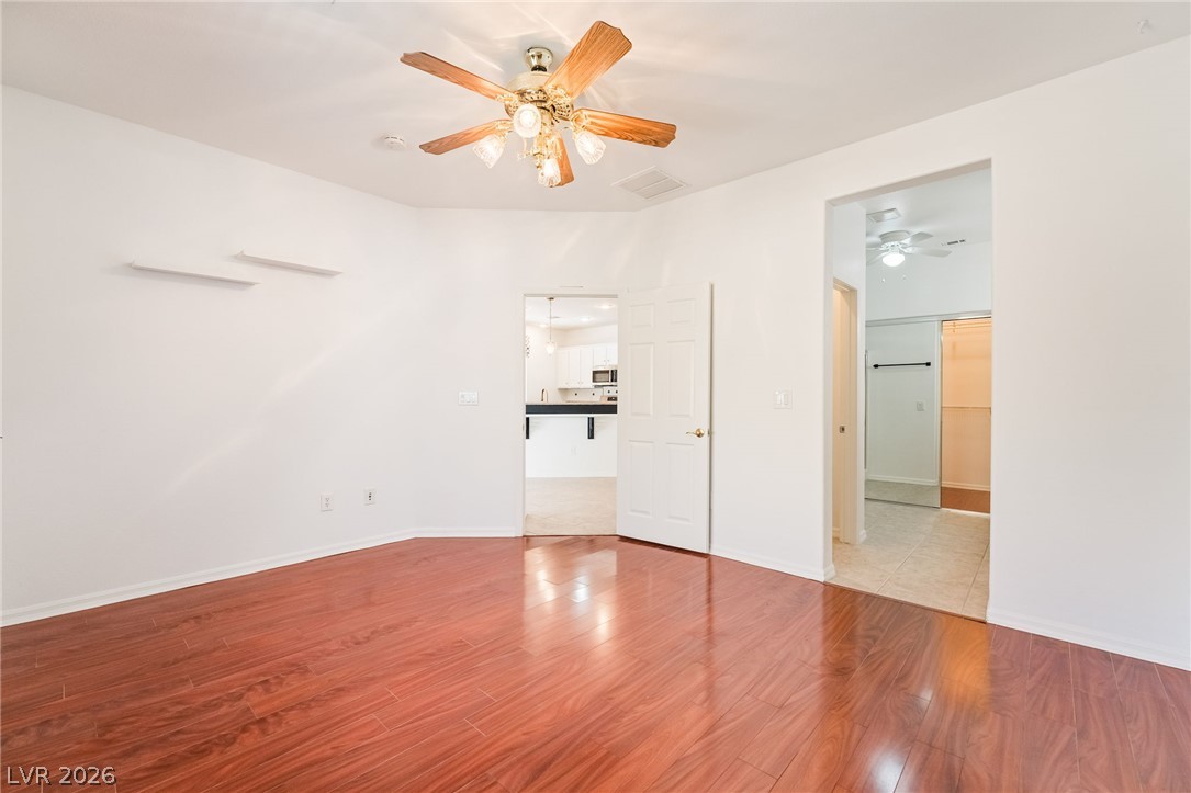 5389 Progresso Street Las Vegas, NV 89135 - Photo 8 of 41 Rich hardwood floors gleam in this well-lit room, featuring a classic ceiling fan for comfort.