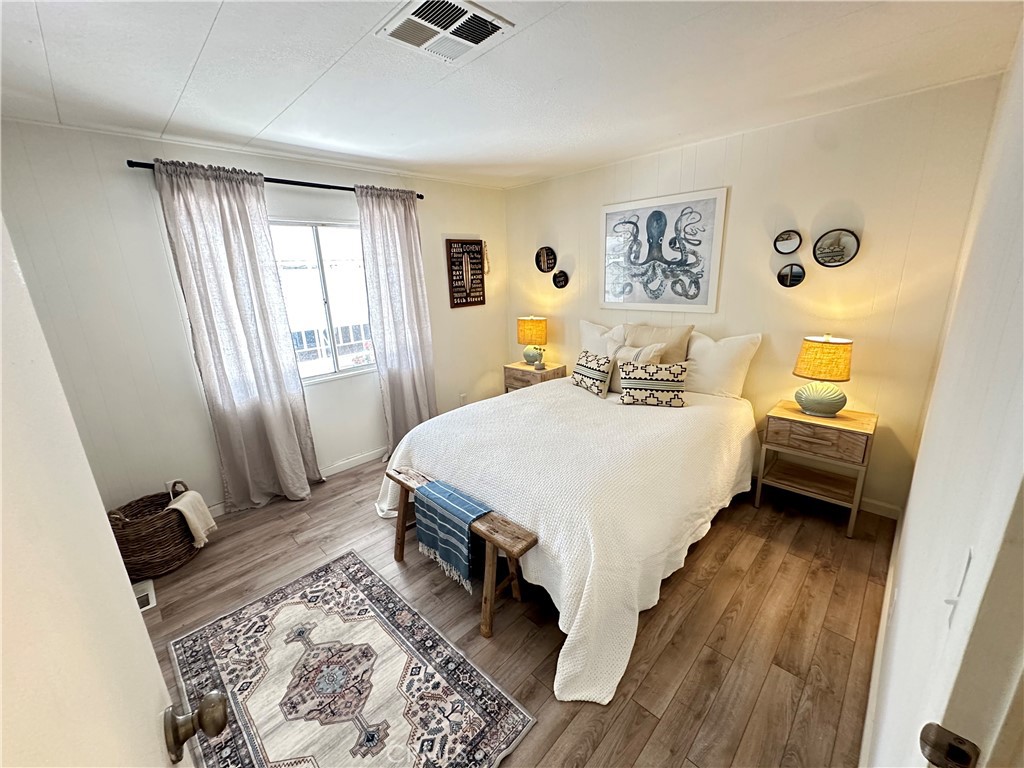 24701 Raymond Way, Unit 45 Lake Forest, CA 92630 - Photo 12 of 14 a bedroom with a bed and wooden floor