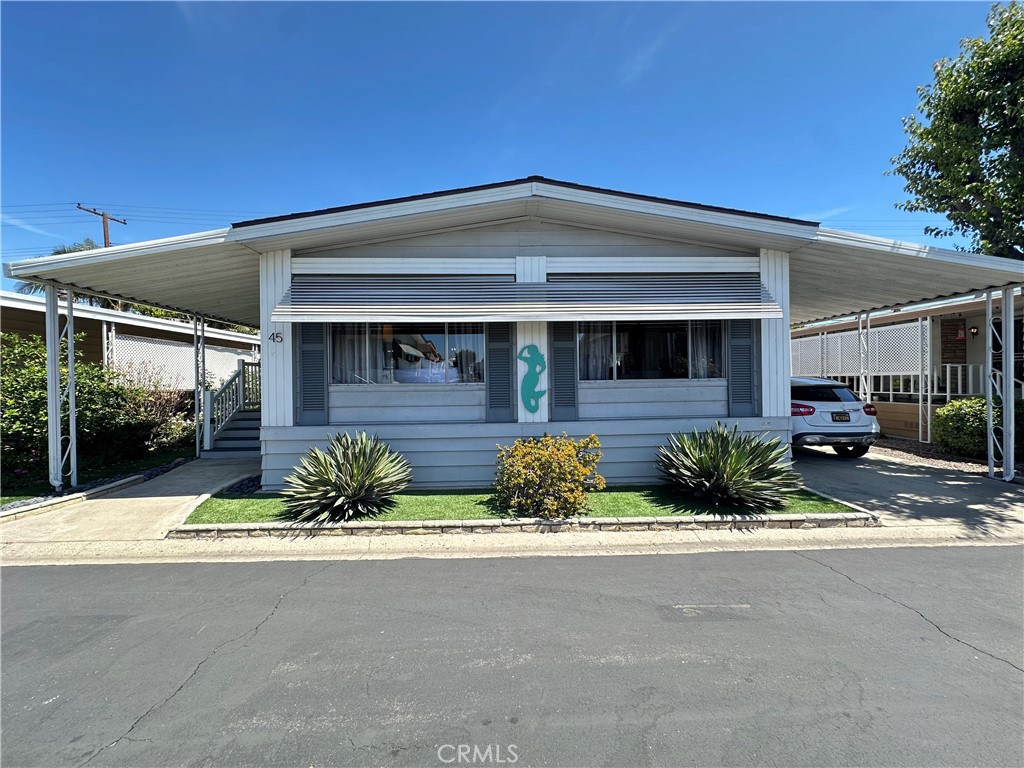 24701 Raymond Way, Unit 45 Lake Forest, CA 92630 - Photo 2 of 14 a front view of a house with a yard outdoor seating and garage
