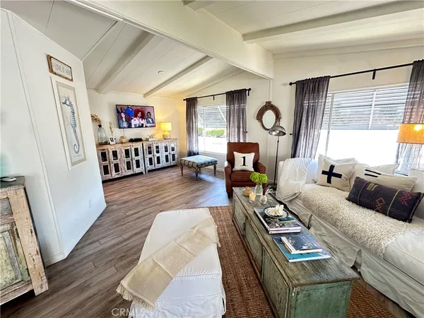 a living room with furniture a flat screen tv and a large window