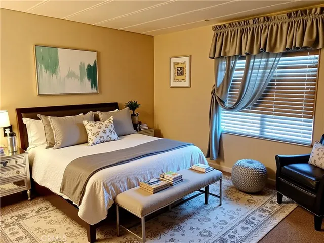 a bedroom with bed and a painting on the wall