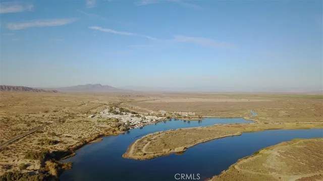 an aerial view of ocean and residential houses with outdoor space