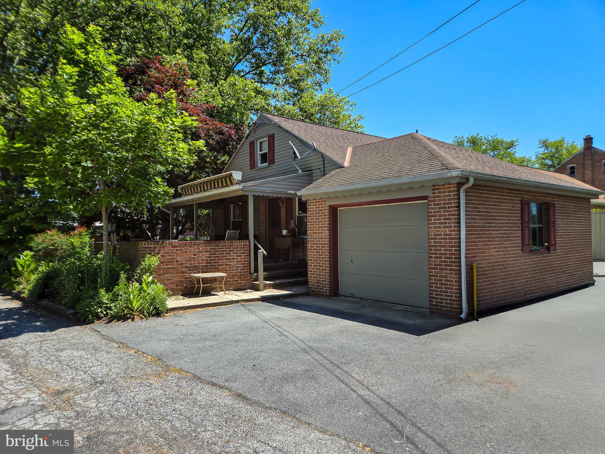 524 Locust Street Denver, PA 17517 - Photo 4 of 36 Charming brick home with lush greenery.