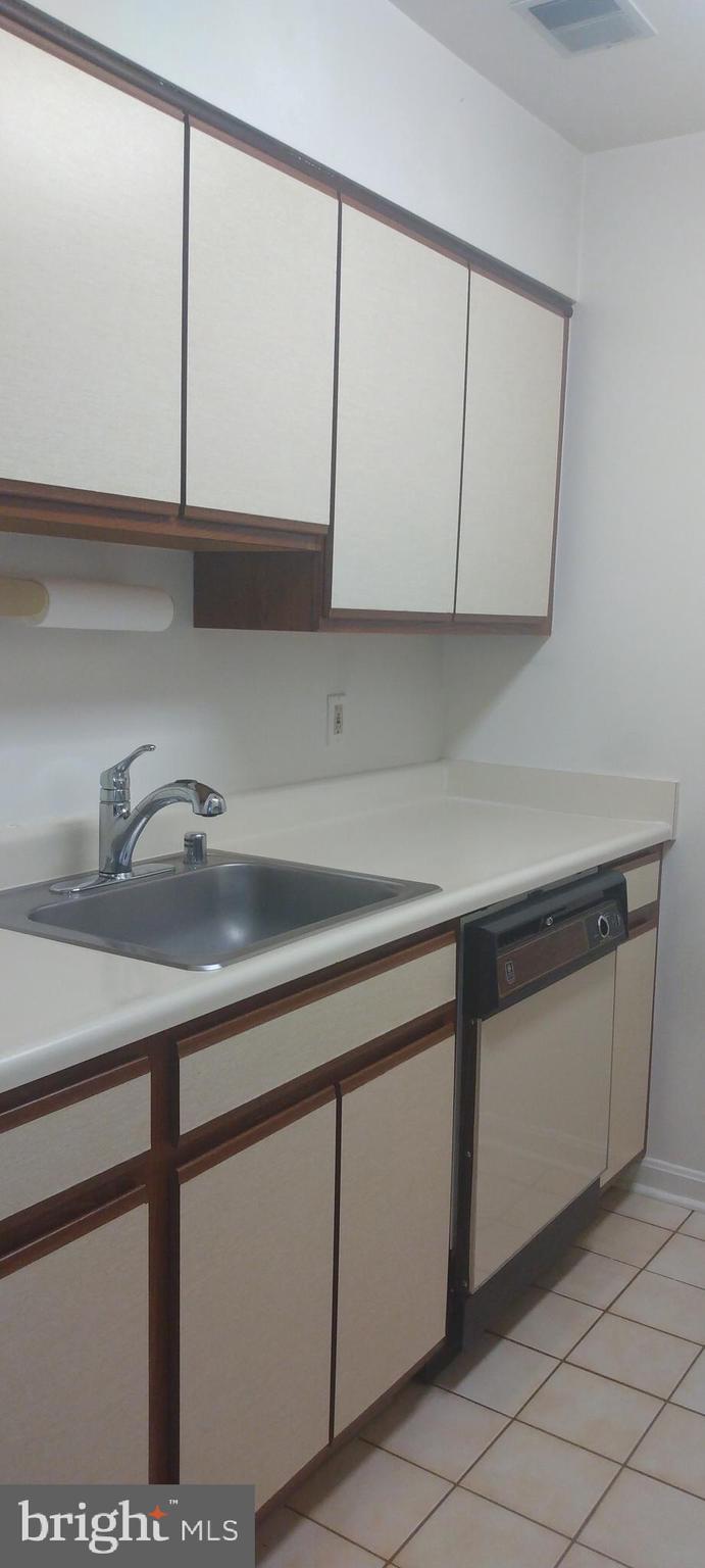 4912 Columbia Road, Unit 1 110 Columbia, MD 21044 - Photo 15 of 59 a kitchen with a sink and cabinets