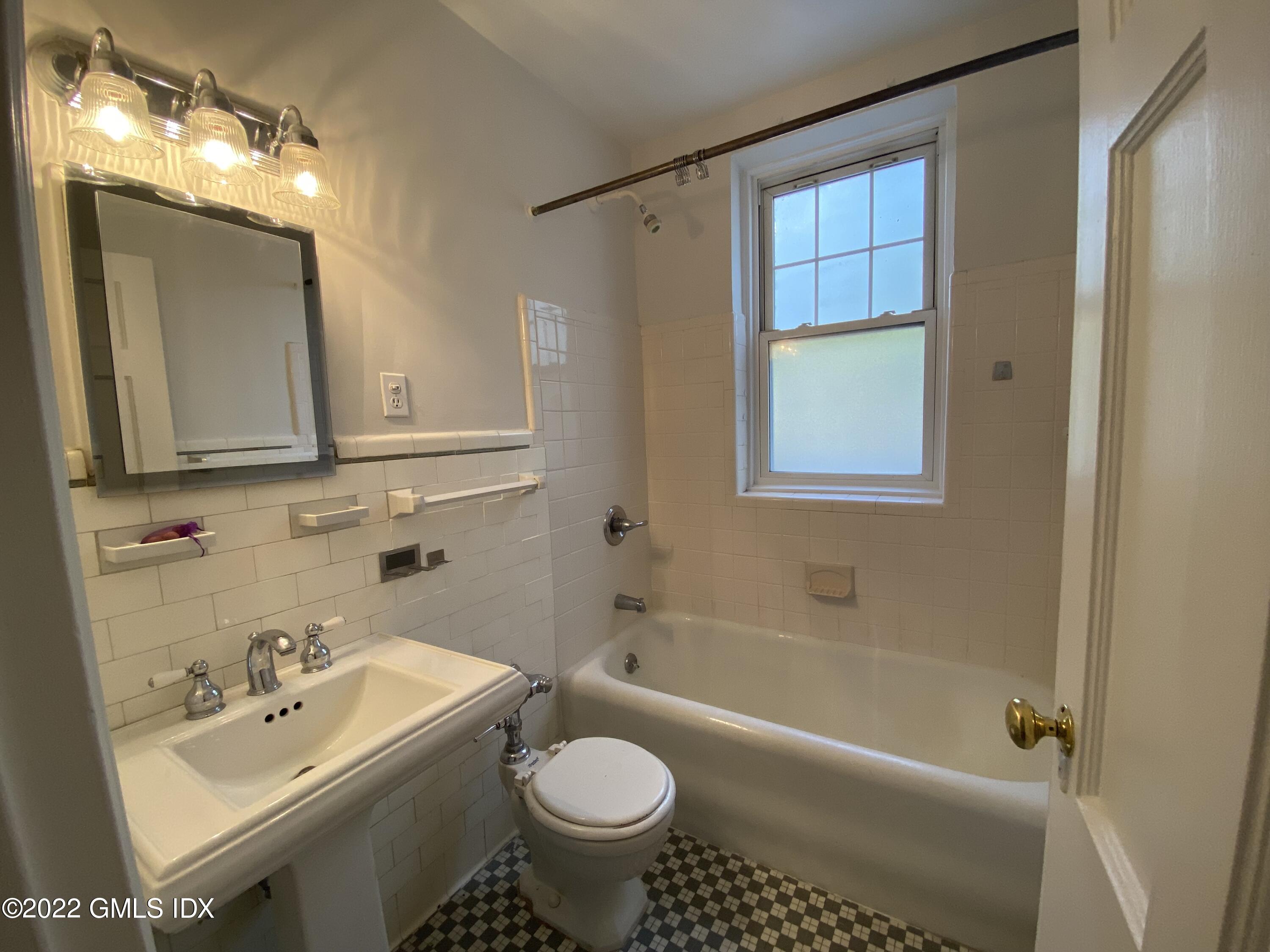 169 Mason Street, Unit 1F Greenwich, CT 06830 - Photo 11 of 14 a bathroom with a sink toilet a bathtub and shower