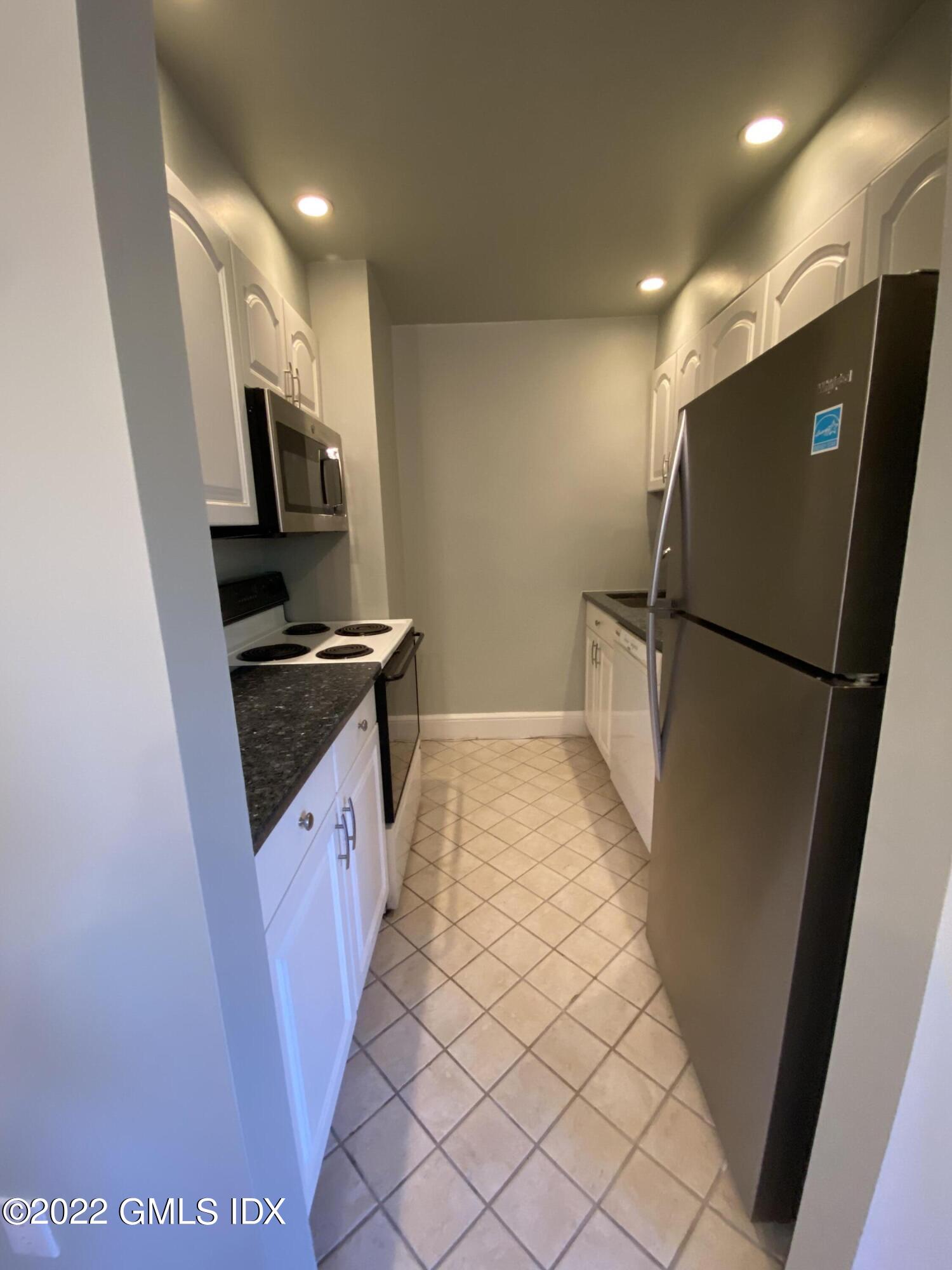 169 Mason Street, Unit 1F Greenwich, CT 06830 - Photo 10 of 14 a kitchen with stainless steel appliances a refrigerator and a sink