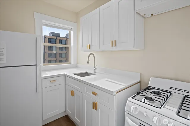 an empty room with wooden floor & windows and bathroom