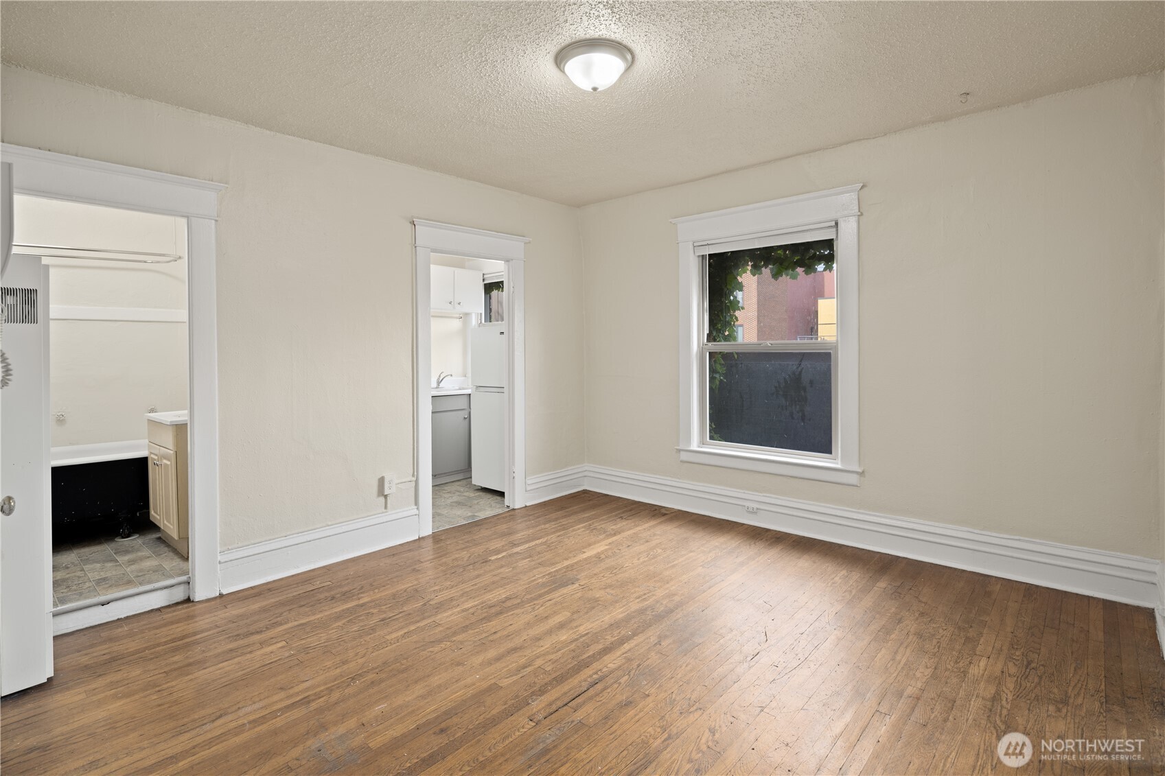 321 Broadway East Seattle, WA 98102 - Photo 19 of 38 an empty room with wooden floor fireplace and windows
