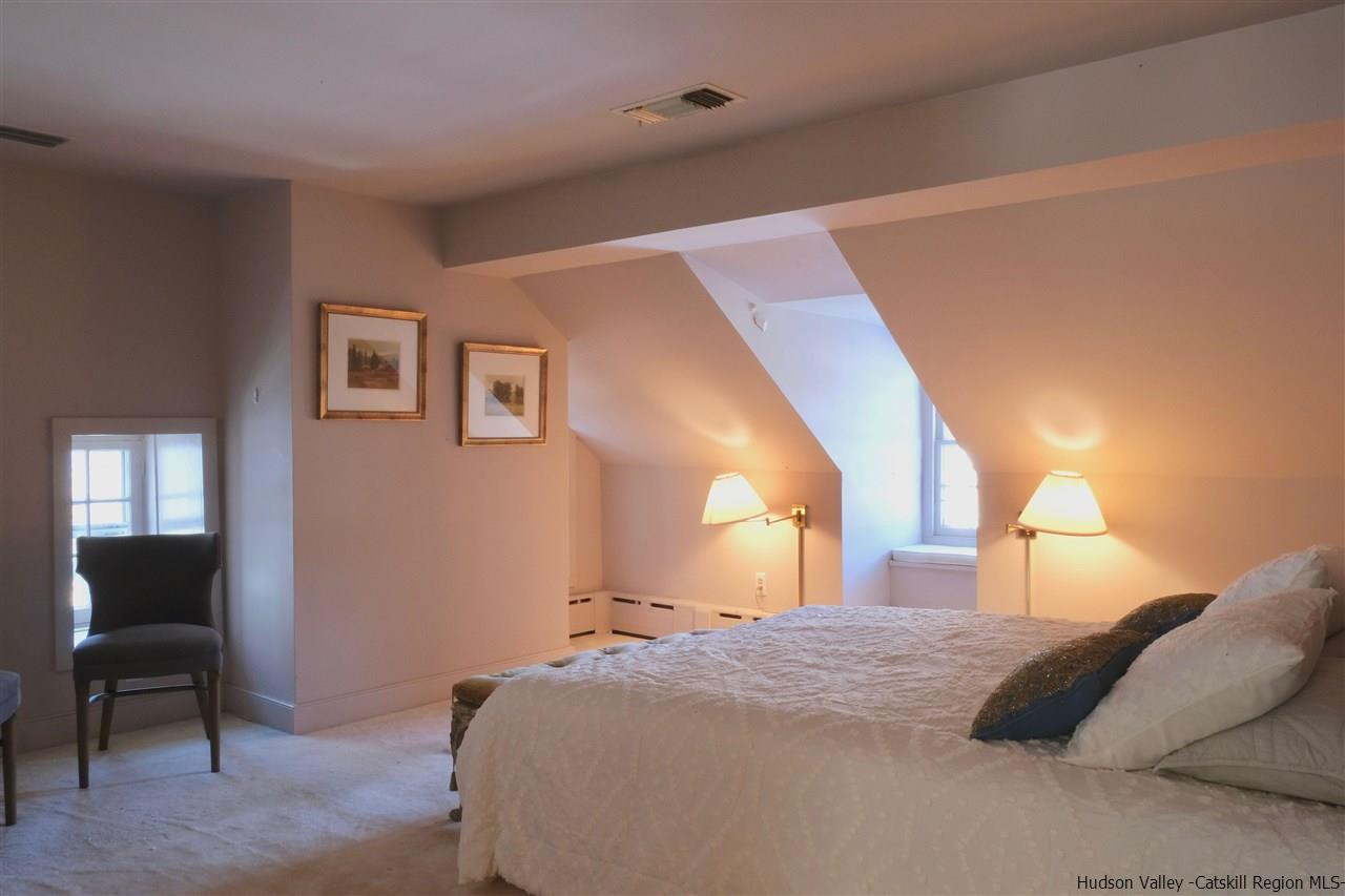 115 Buck Road Stone Ridge, NY 12484 - Photo 20 of 35 a bedroom with a bed and a chair