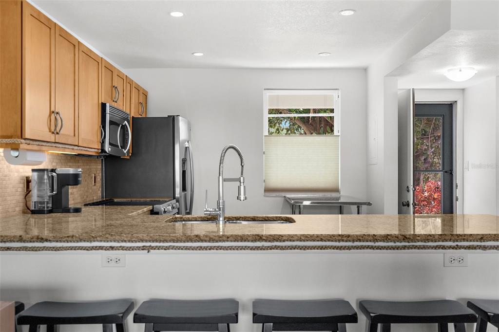 600 Sutton Place, Unit 101B Longboat Key, FL 34228 - Photo 12 of 53 a kitchen with granite countertop a sink and cabinets